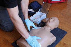 AED being placed on first aid dummy